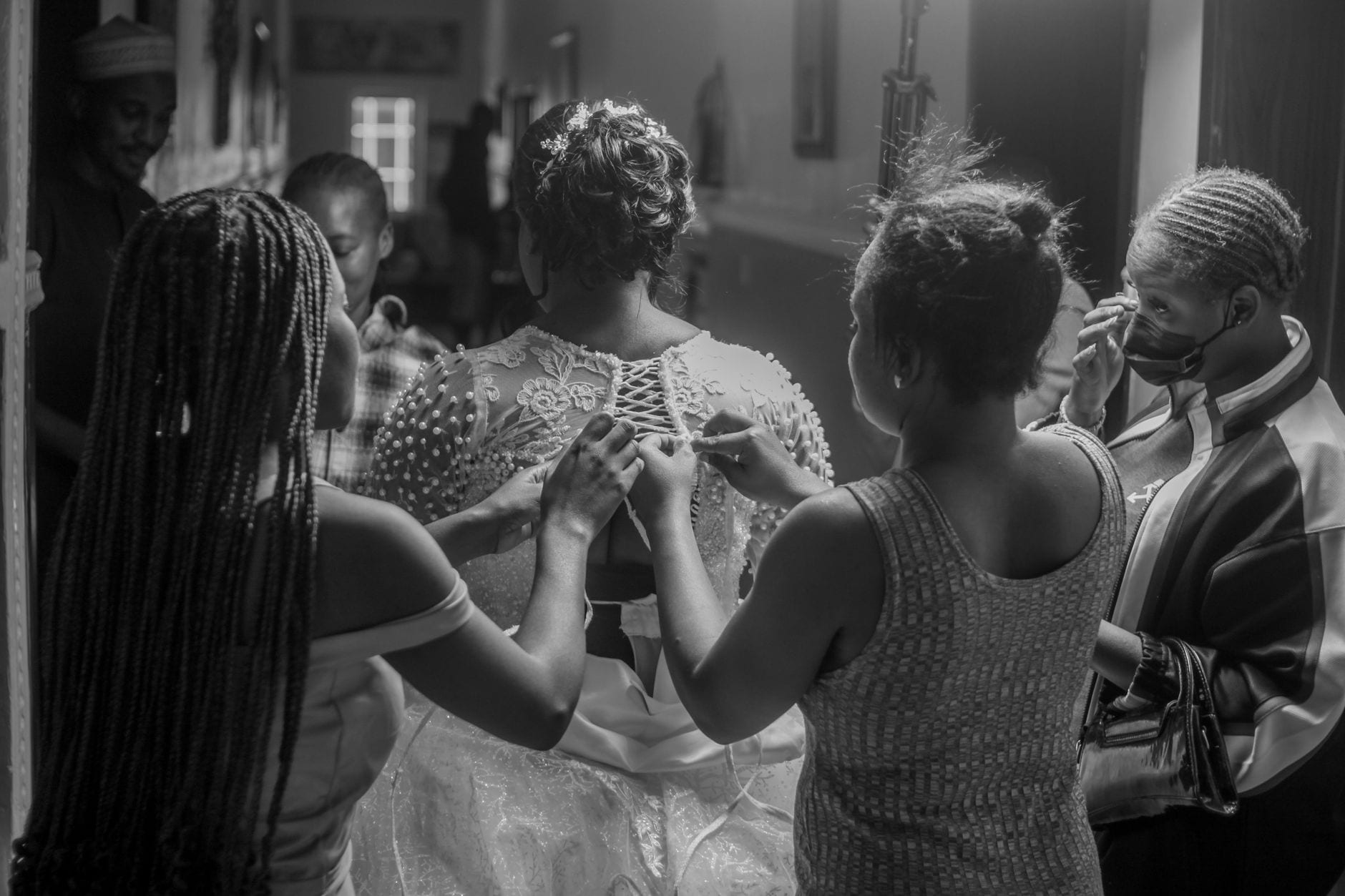 Braut beim Anziehen des Kleides im Studio
