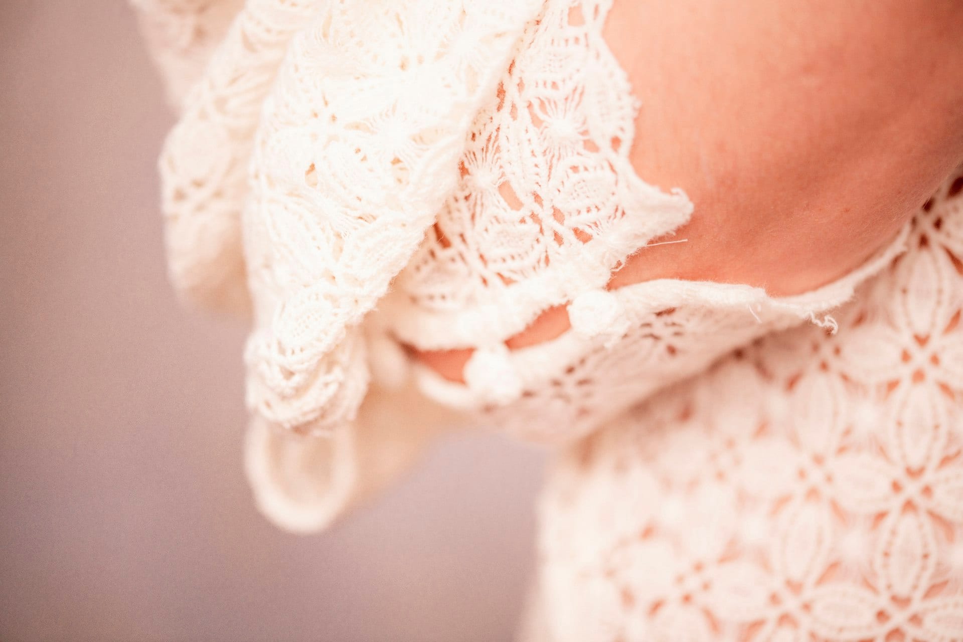Nahaufnahme feiner Spitze an einem Brautkleid